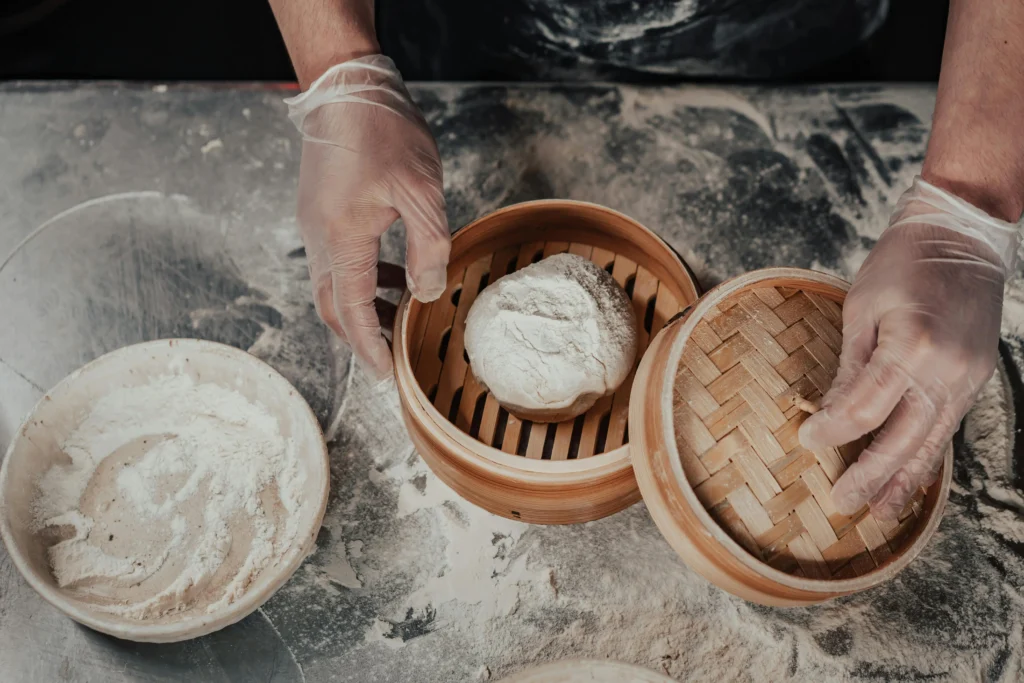 Hands kneading fresh pasta dough on a floured countertop, demonstrating how to make pasta dough at home