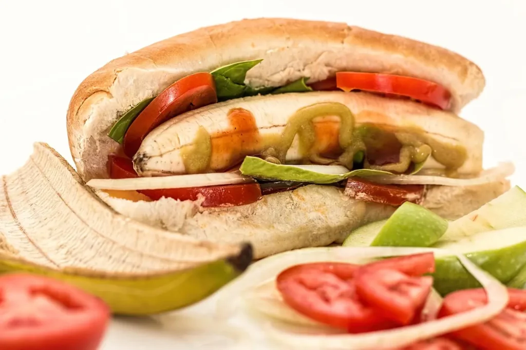 Creative vegan hot dog with plant-based sausage, mustard, pickles, and crispy onions