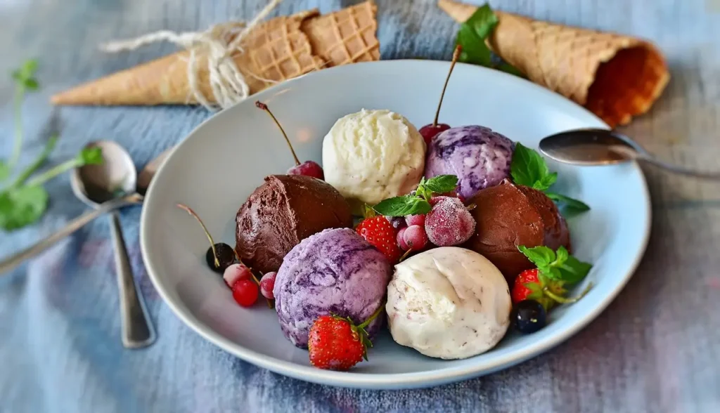 Scoops of artisan vegan ice cream in cones with unique flavors like coconut-mango