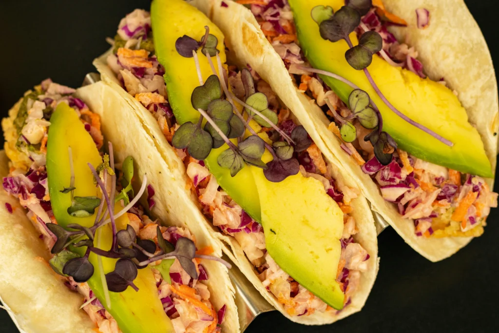 Gourmet vegan tacos with colorful fillings like jackfruit, avocado, and fresh salsa